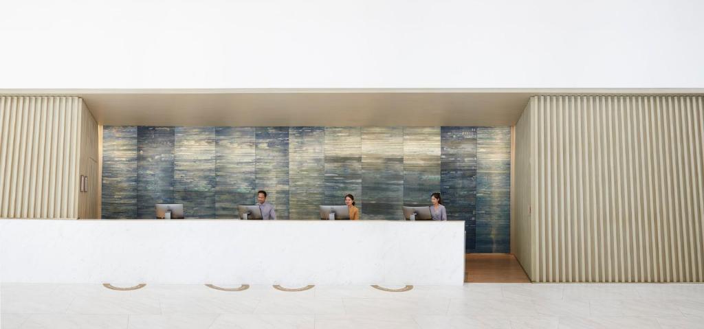 A minimalist reception desk backed by a textured blue wall.
