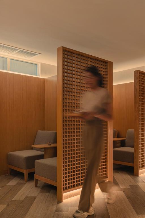 A warm, wood-screened waiting area with lounge seating.