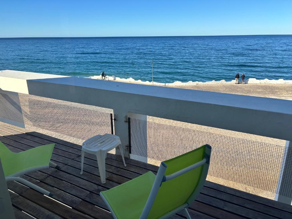 a balcony with a table and chairs and the beach at Bahia creek in Las Grutas