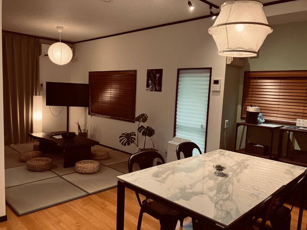 a living room with a table and chairs in it at HOUSE26 Private Villa near Green Expo Yokohama in Machida