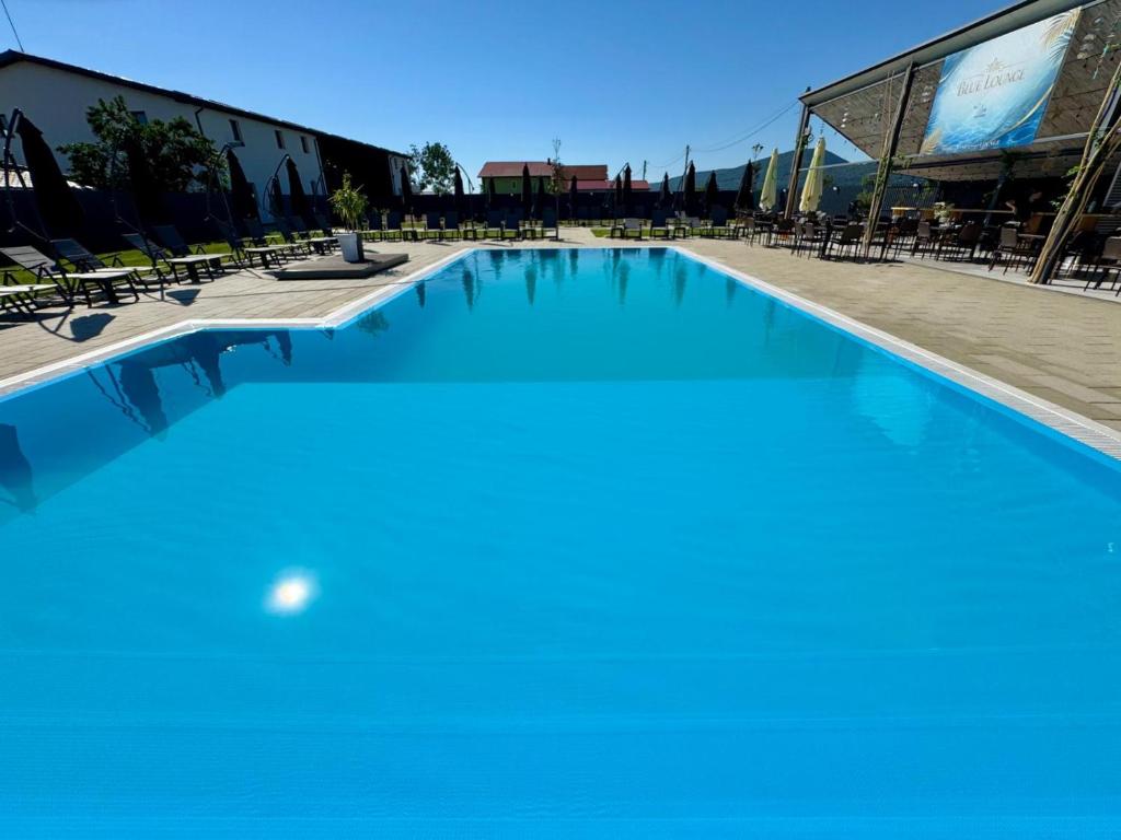 a large swimming pool with blue water and chairs at La Chambre in Ineu