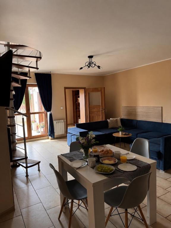 a living room with a table and a blue couch at Pod skrzydłami in Miłomłyn