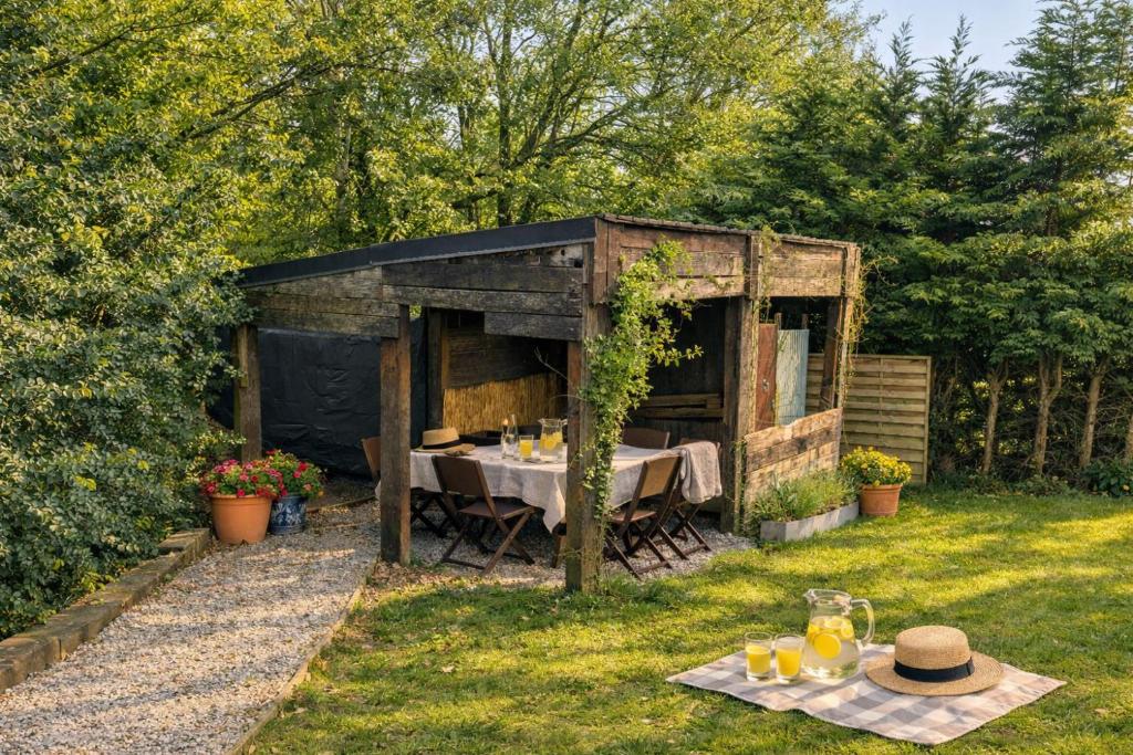 a wooden shed with a table in the grass at Chalet - l'Endoxyle in Froid-Chapelle