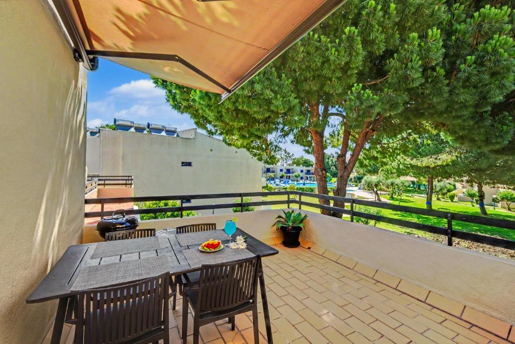 a patio with a table and chairs and an umbrella at Hakuna Matata House in Alvor
