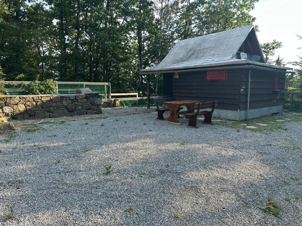 a building with a picnic table and a bench at Palčkov oddih in Škofja Loka