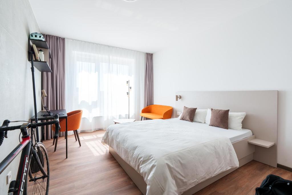 a hotel room with a bed and a bike in it at Boardinghouse Air Tech Campus - smart Check-in in Weßling