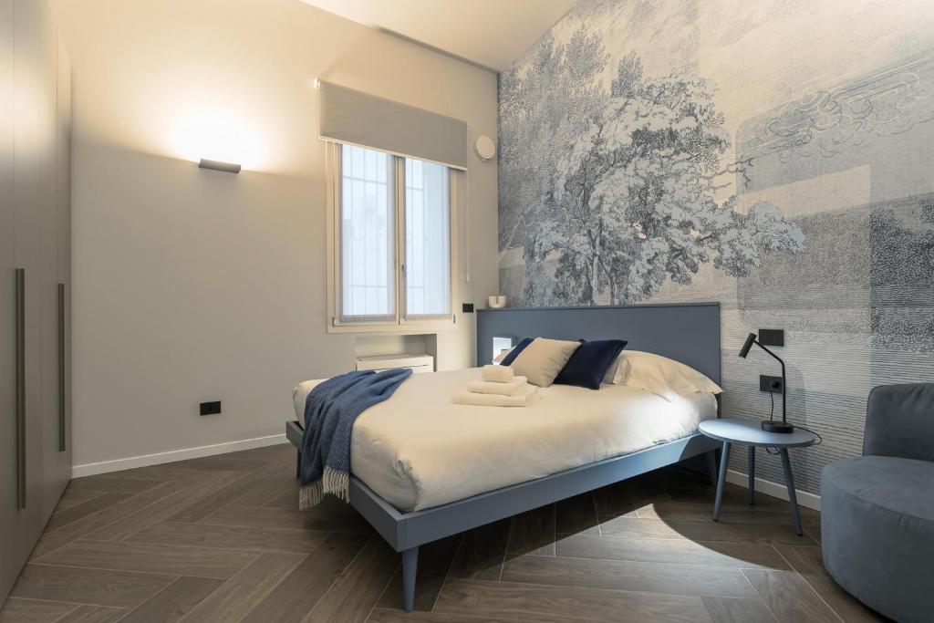 a bedroom with a bed and a painting on the wall at GuestHost - Vivaldi Inverno Apartment in Treviglio
