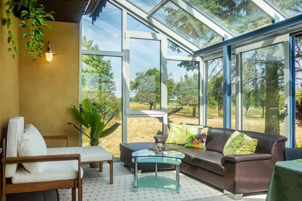 a conservatory with a couch and a table at Hesselberg-Oase Ferienhof Hüttner in Röckingen