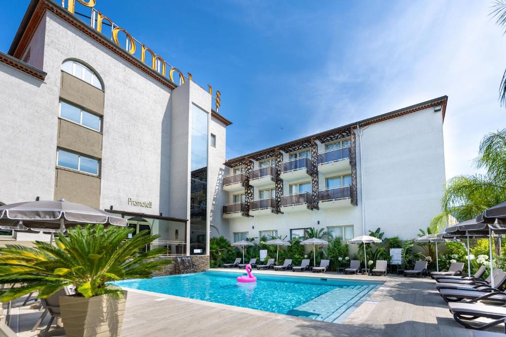 a swimming pool in front of a hotel at Promotel in Carros