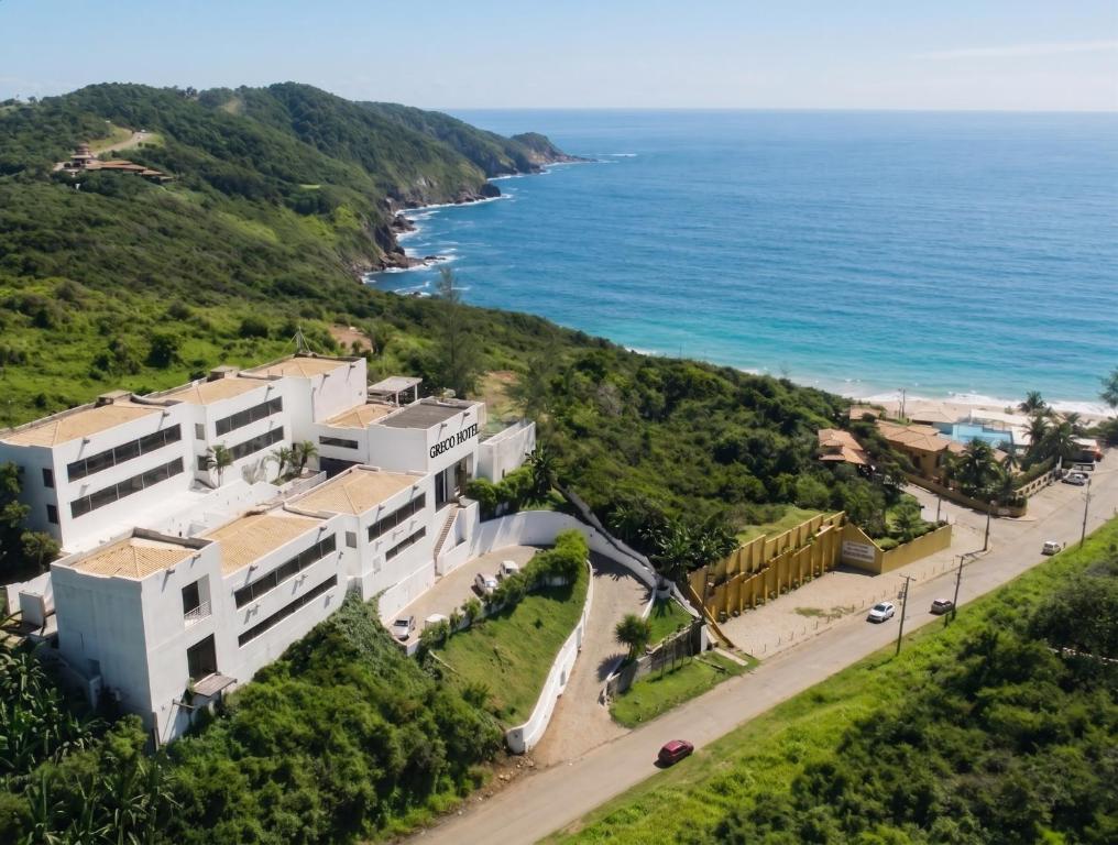 an aerial view of a building next to the ocean at Greco Hotel in Búzios