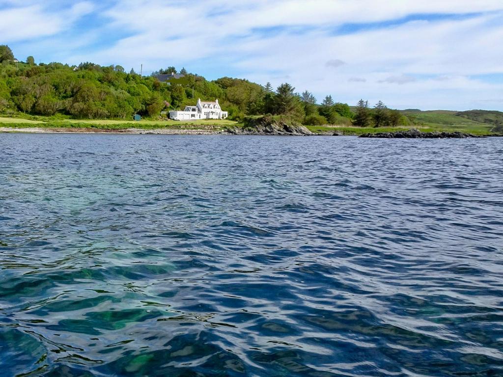 a house on the shore of a large body of water at South Bay Cottage in Saasaig