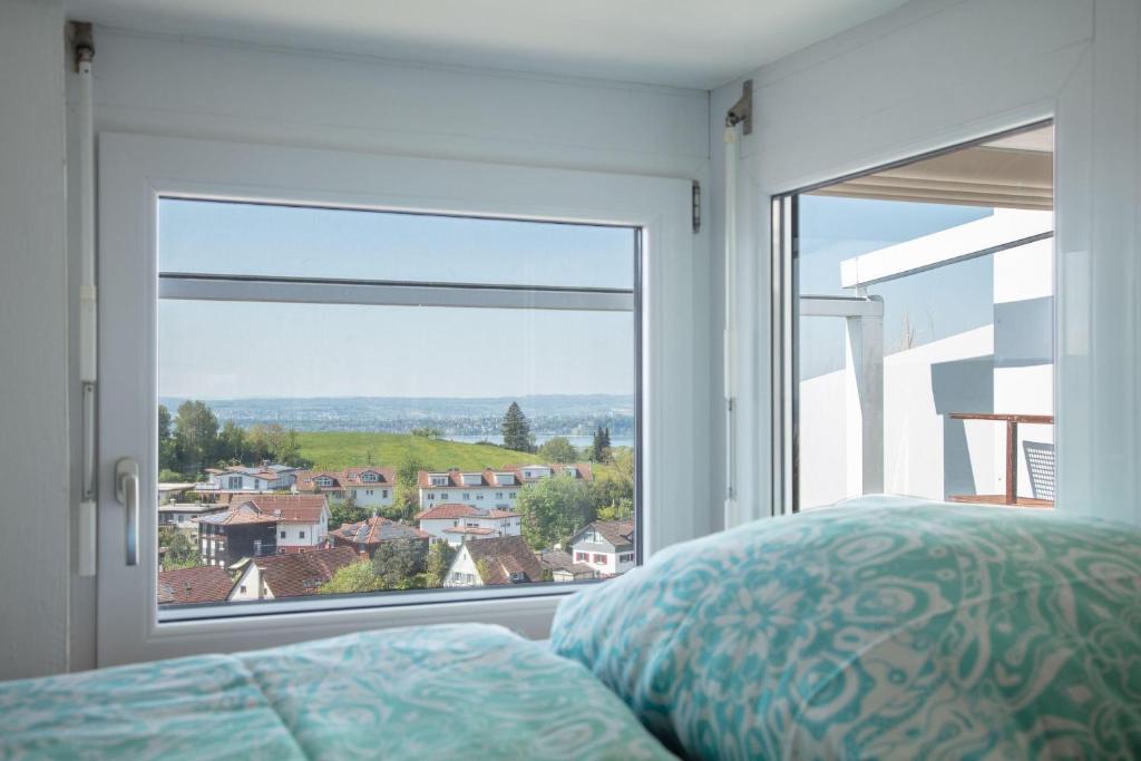 a bedroom with a large window with a bed and a view at Apartment Lichterfunkeln für junge Paare mit Panorama-Seeblick in Daisendorf