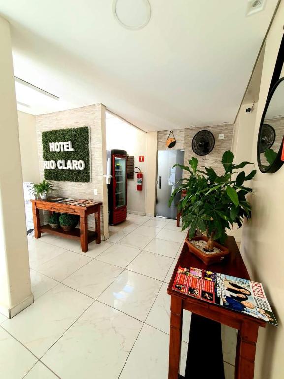 a living room with a table and a refrigerator at Hotel Rio Claro in Rio Claro