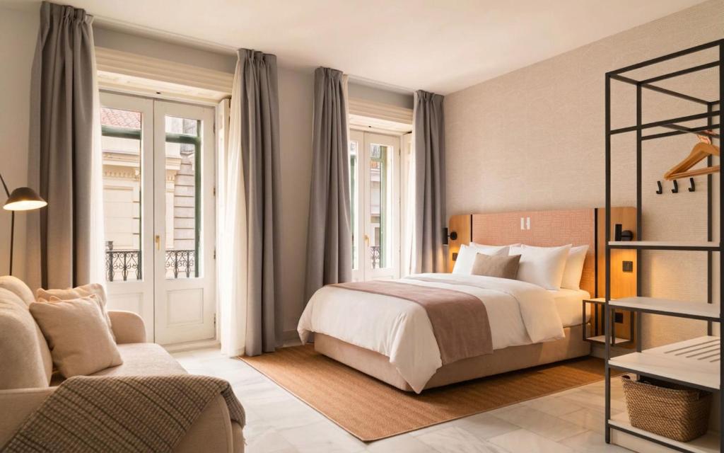 a hotel room with a bed and a couch at Limehome Madrid Sol in Madrid