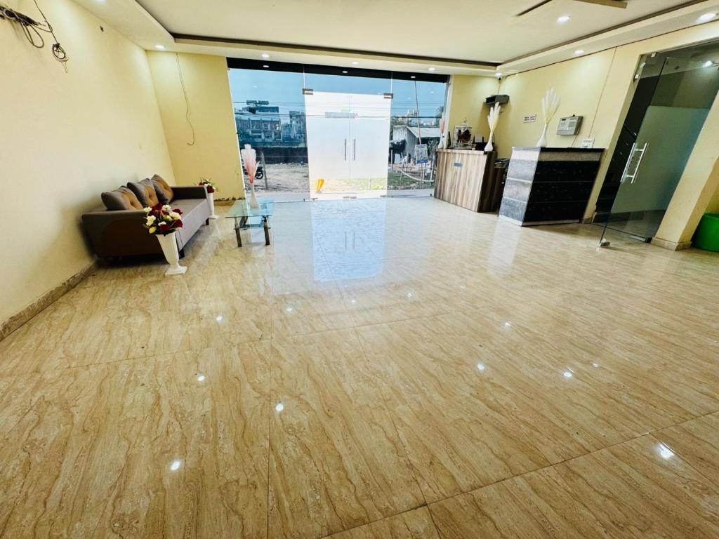 an empty lobby with a couch and a table at Hotel O Manglam Hotel in Chinhat