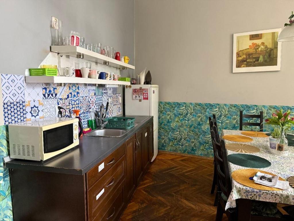 a kitchen with a sink and a microwave on a counter at GREEN HOUSE Hostel in Krakow