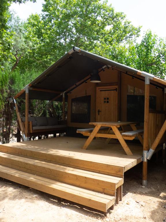 eine Hütte mit Holzdeck und Tisch in der Unterkunft Anna Glamping in Fuen Negra
