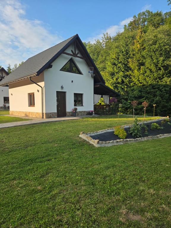 a white house with a black roof at Jagodowa Czulnia in Zwierzyń