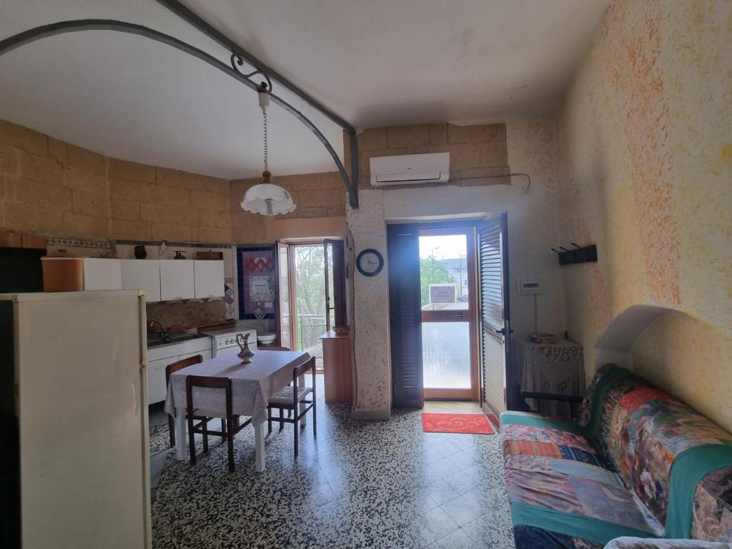 a kitchen and dining room with a table and a couch at Luce in Montescaglioso