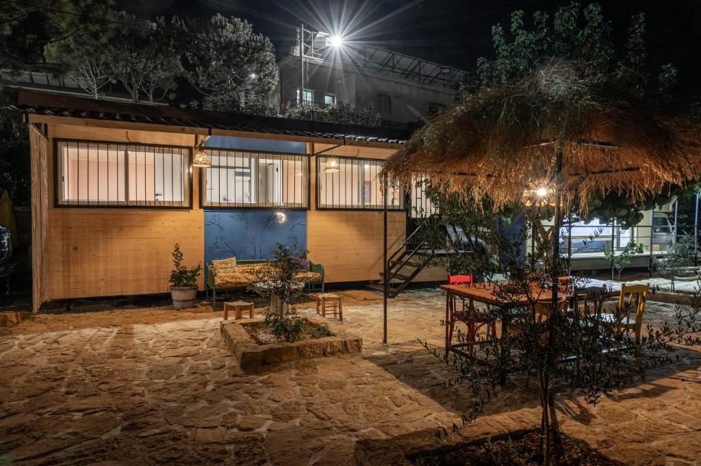 a restaurant with a table and chairs and a building at Maison Jwar - Charming Caravan Experience - Unique Summer Getaway in Jiwār al Ḩawz