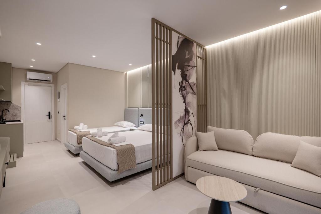 a bedroom with a bed and a couch and a mirror at Marea Suites Borsh in Borsh