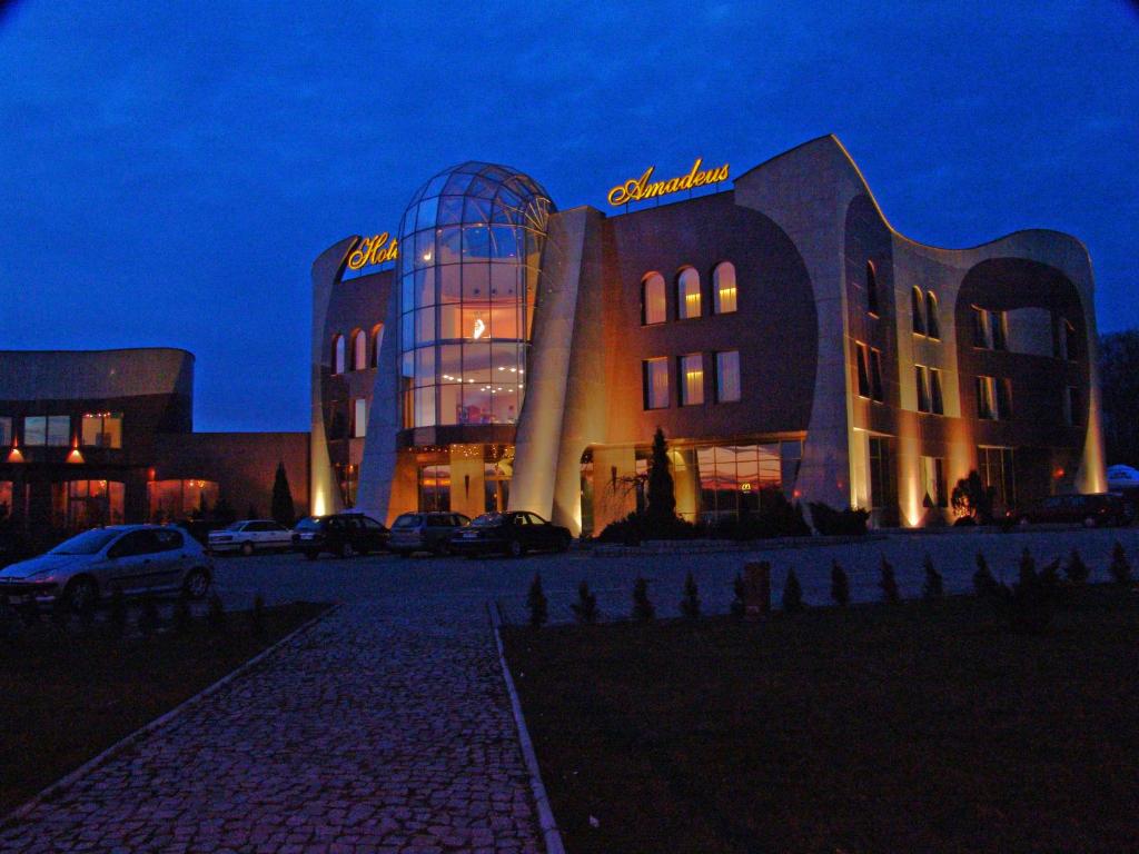 un edificio con un'auto parcheggiata di fronte di Hotel Amadeus a Wodzisław Śląski