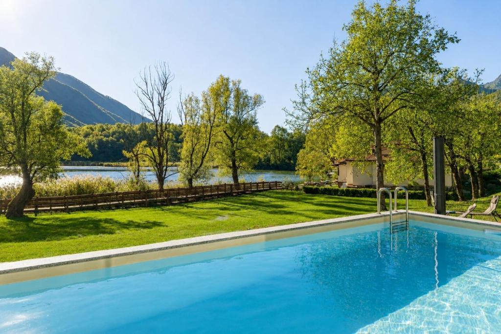 a swimming pool with a view of a lake and mountains at Como home residence in Carlazzo