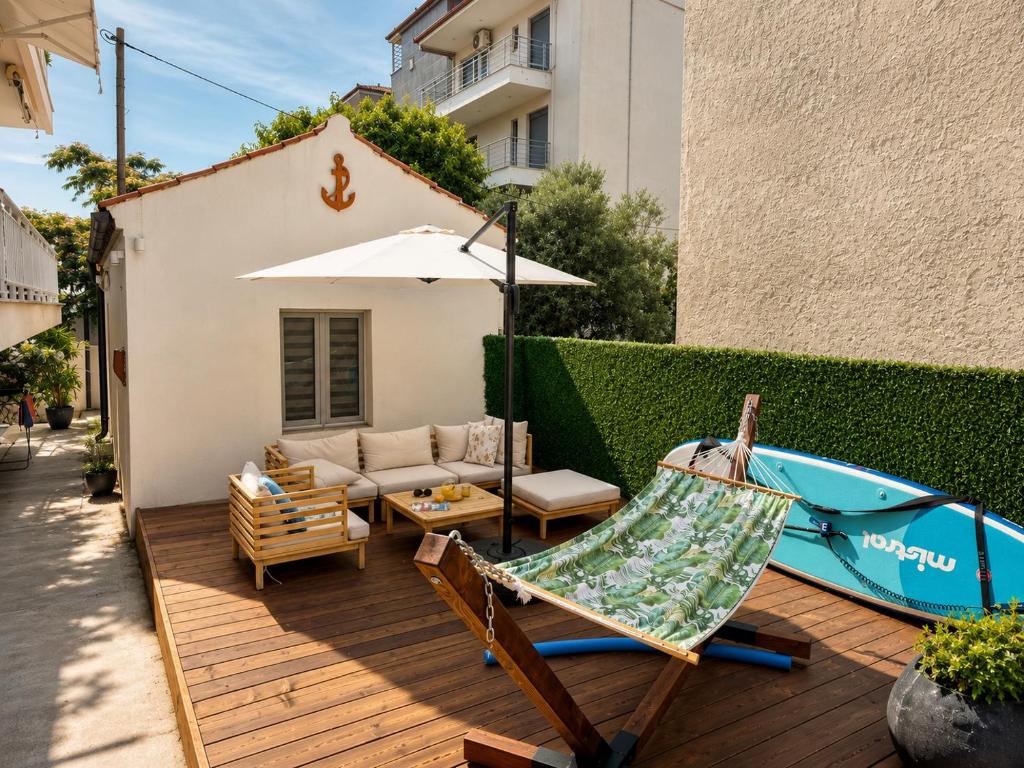 a patio with a couch and an umbrella and a hammock at Teo's house in Asprovalta