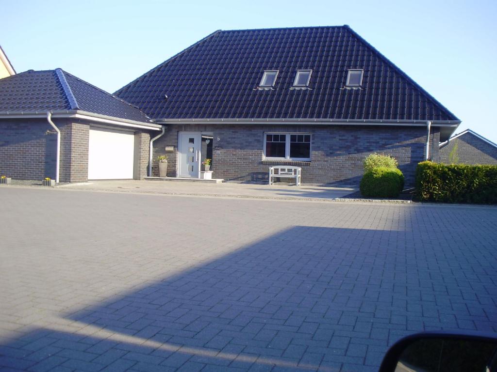 a house with a brick driveway in front of it at Ferienwohnung im Schellenpark in Tarp
