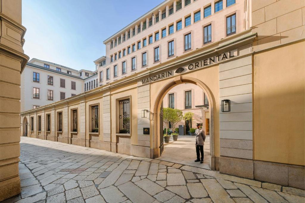 a man walking down a street in front of a building at Mandarin Oriental, Milan in Milan