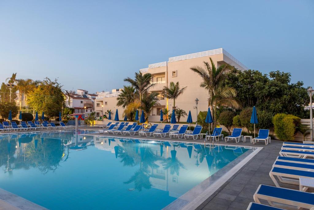 a swimming pool with chairs and a hotel at Euronapa Hotel in Ayia Napa