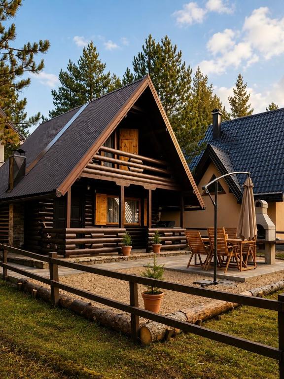 a house with a gambrel roof with a patio at Planinski šapat in Blidinje