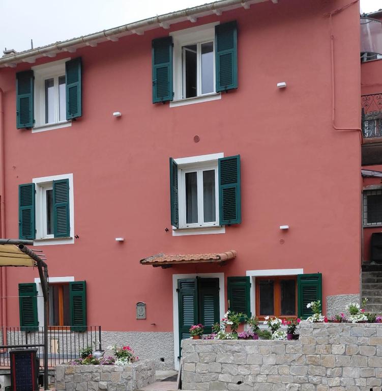 Casa Codeglia في ريكو ديل غولفو دي سبيزيا: مبنى وردي اللون ذو مصاريع خضراء