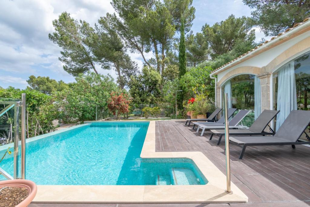 a swimming pool with lounge chairs next to a house at Villa Romana Bonaire in Cielo de Bonaire 