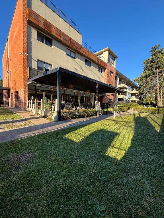 a building with a grass field in front of it at Pilar Suites by Viva in Pilar