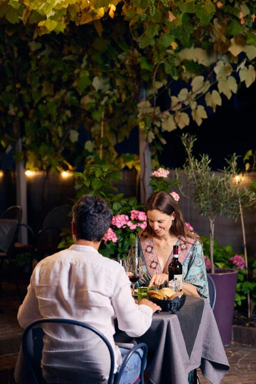 a man and a woman sitting at a table at Rolly - Rooms & Restaurant in Riva del Garda