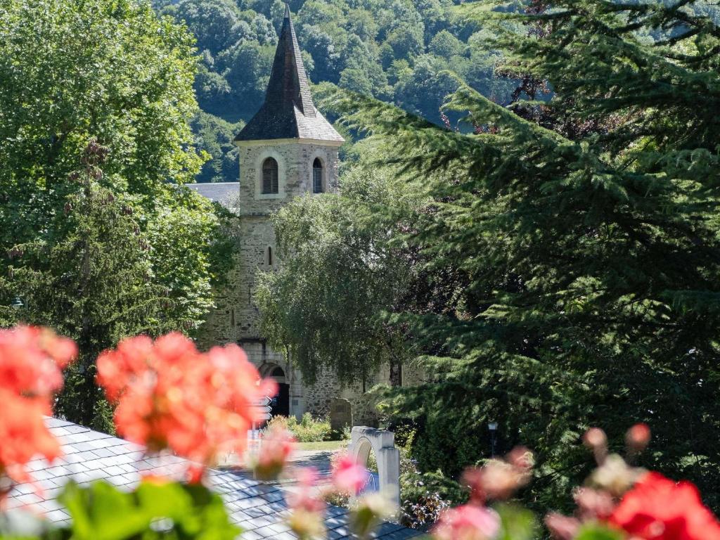 an old church with a steeple in the midst of trees at Mercure Saint-Lary in Saint-Lary-Soulan