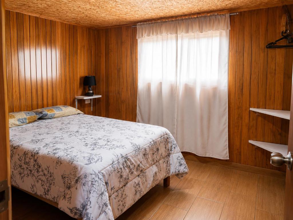 a bedroom with a bed and a window at Böttger Haus in Oxapampa