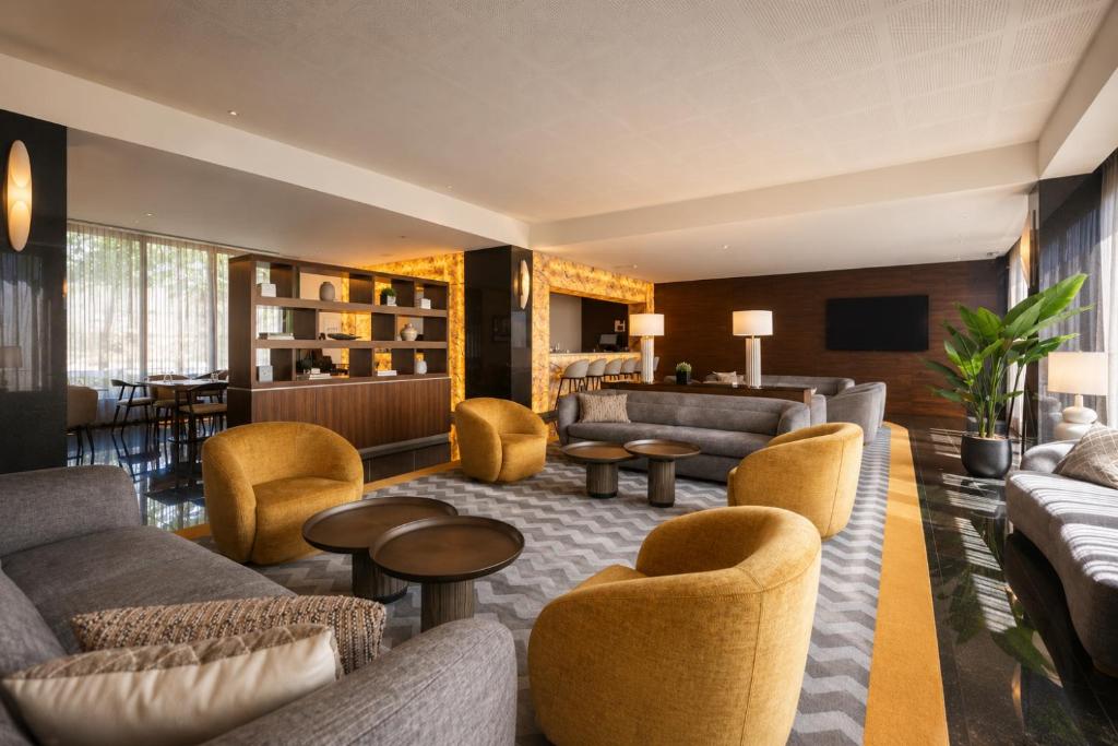 een hotellobby met banken, stoelen en tafels bij BessaHotel Boavista in Porto