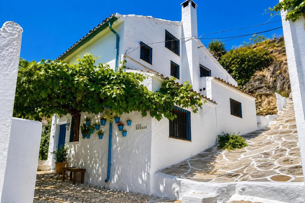 a white building with a tree in front of it at 2-Bed Country House - Mountain Views - Sleeps 6 in Rute