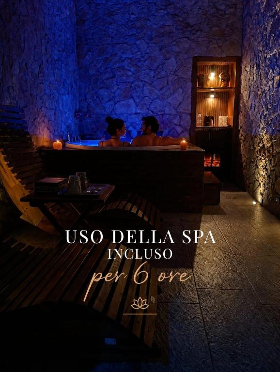 two people sitting at a bar in a restaurant at SPA ROOM SICILIA - Suite con Spa ad uso esclusivo Jacuzzi Sauna Hammam in Rosolini
