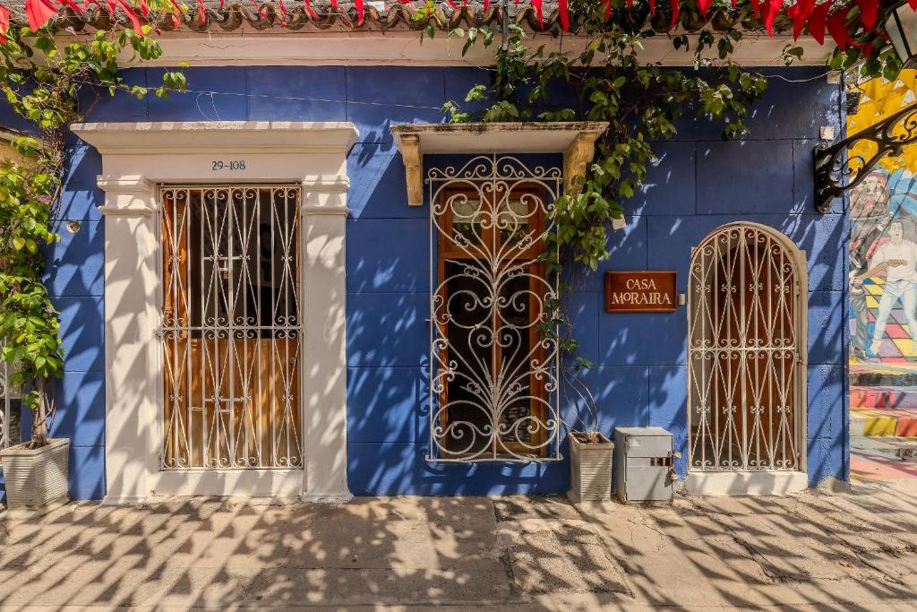 a blue building with a gold door and gates at Casa Moraira in Cartagena de Indias