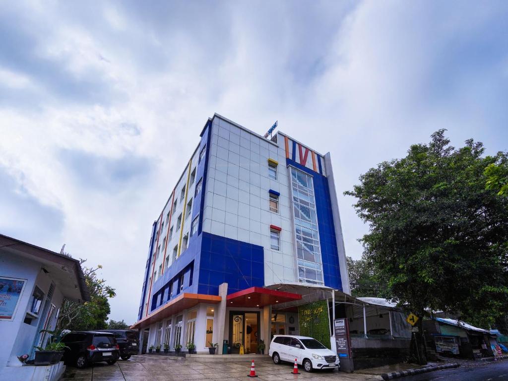 a blue building with a white car parked in front of it at Sparks Odeon Sukabumi, ARTOTEL Curated in Sukabumi