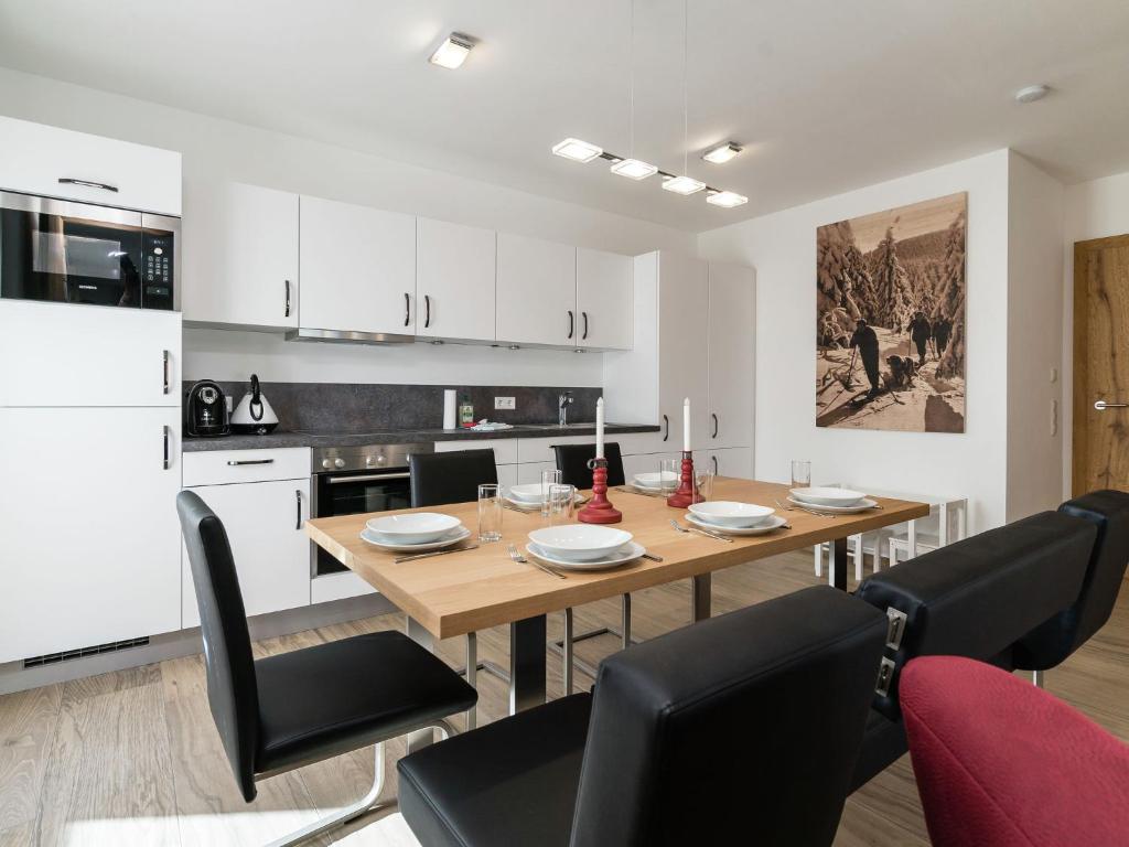 a kitchen and dining room with a wooden table and chairs at Beautiful apartment near the ski area in Hollersbach im Pinzgau