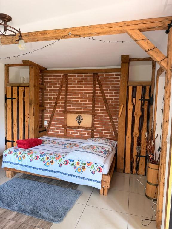 a bed in a room with a brick wall at Uroczysko in Brenna
