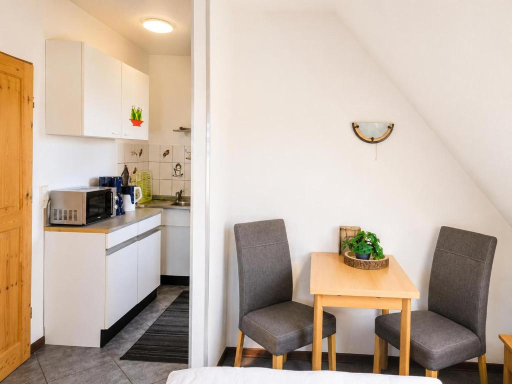 a small kitchen with two chairs and a table at Küstenlounge Dornumersiel in Dornum