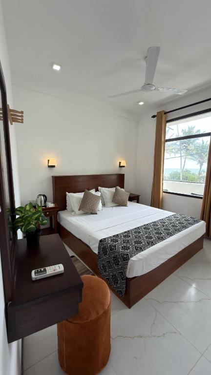 a bedroom with a bed and a table and a window at Induwara Villa in Ahungalla
