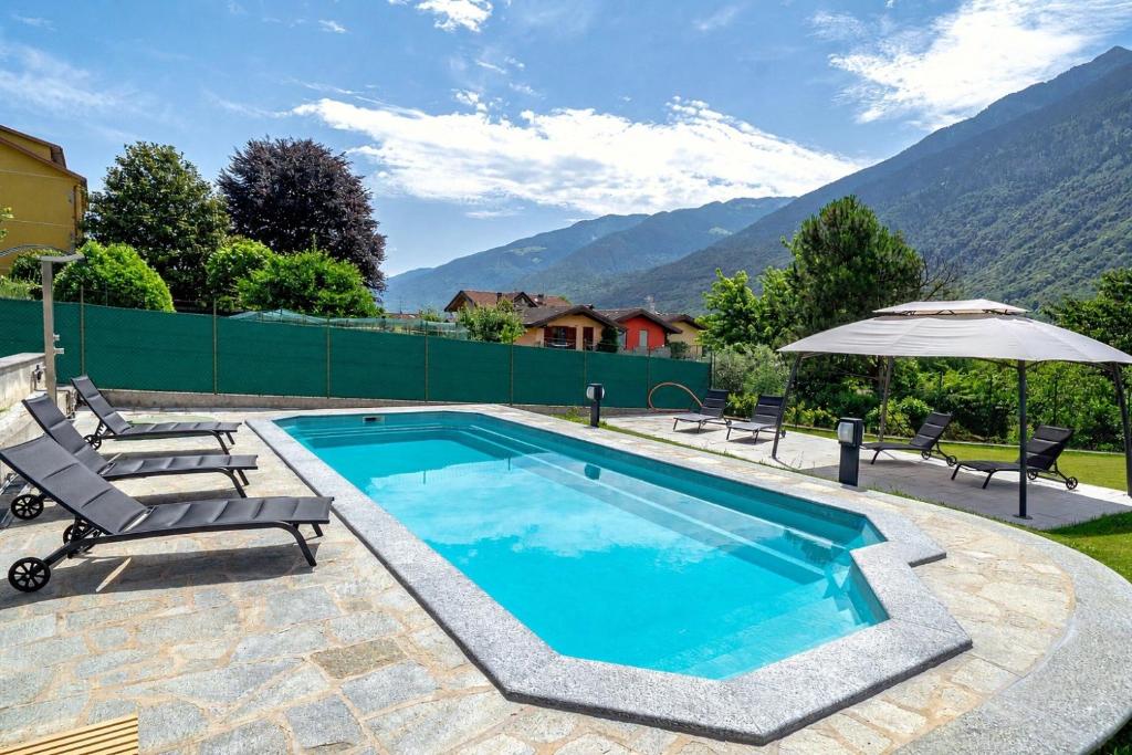 a swimming pool with two chairs and an umbrella at Spinedi Royale in Postalesio
