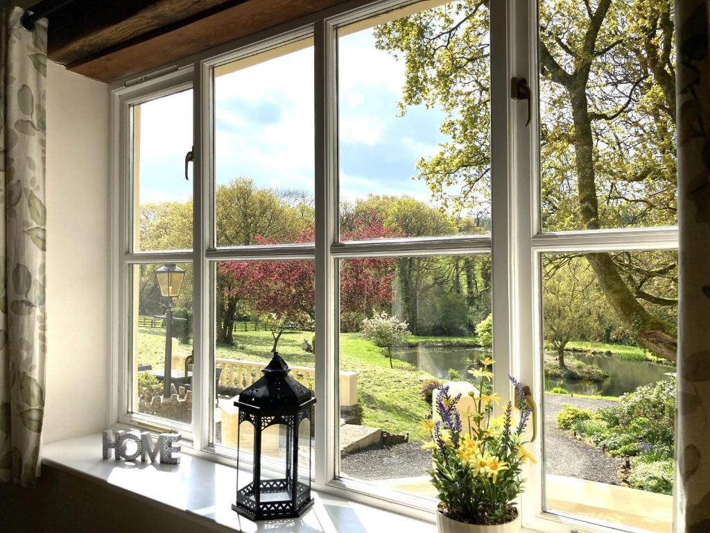 an open window with a view of a garden at Pheasants Roost With Indoor Pool In Devon in Broadwoodkelly