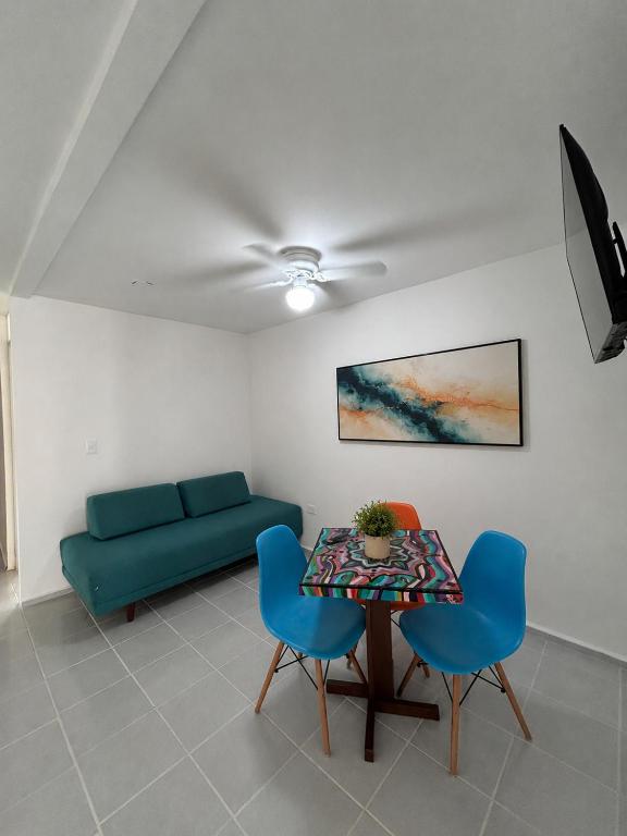 a living room with a table and blue chairs at Casa Balam Cayo Lobo in Cancún